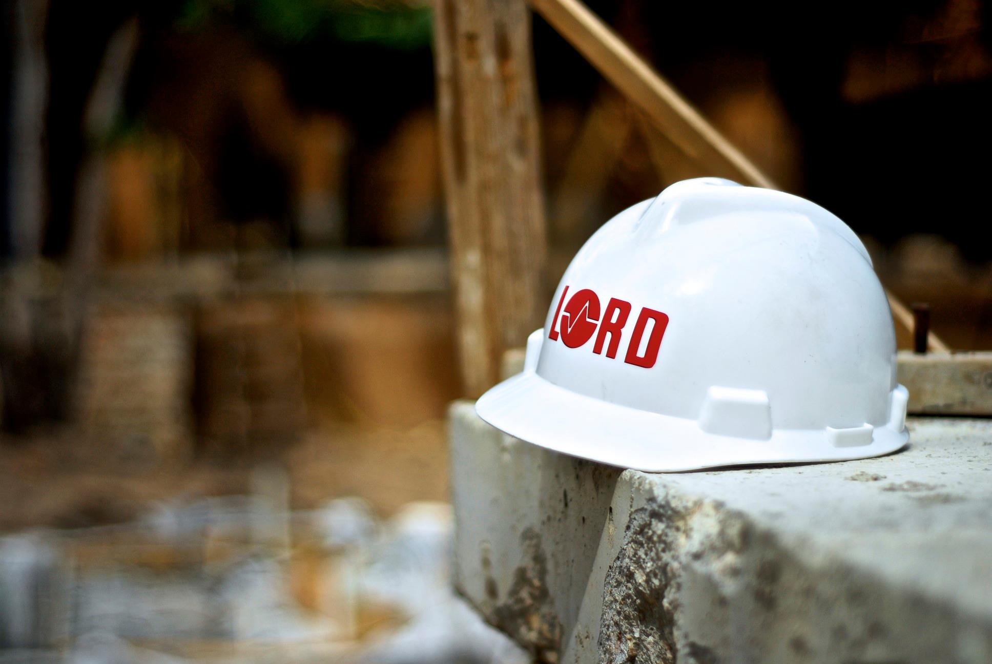 Hart hat with LORD logo on concrete slab