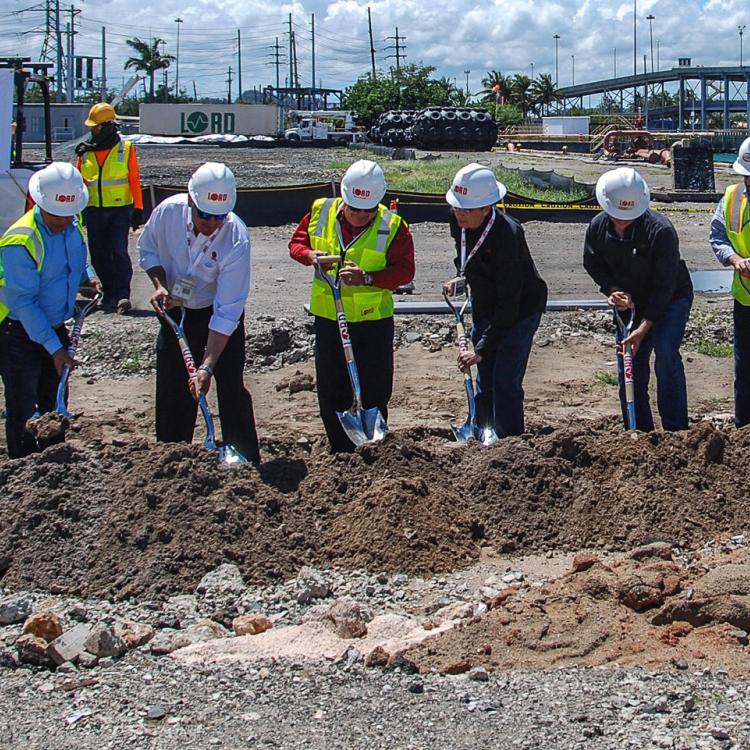 Team of construction employees shoveling dirt to inaugurate a new project