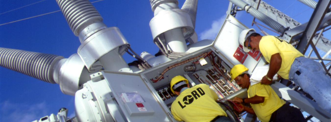 Three electrical workers with industrial transformer