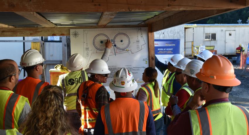 Construction workers meeting in front of building plans